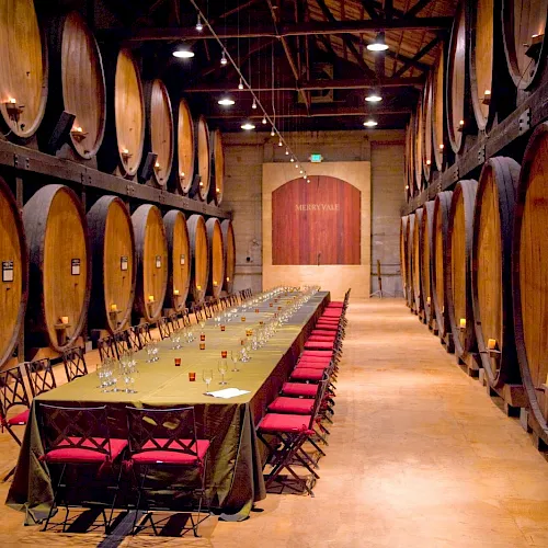 Oak wine barrels lining a winery barrel room